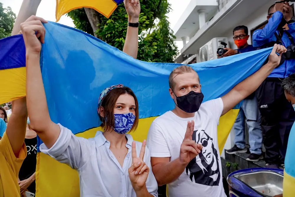 01 March 2022, Indonesia, Denpasar: A couple wears the Flag of Ukraine to cover their body. Hundreds of Ukrainian citizens and pro-Ukraine supporters in Bali held a peace rally against Russia's invasion of Ukraine at the Bajra Sandhi Monument of Denpasar. Photo: Dicky Bisinglasi/ZUMA Press Wire/dpa.