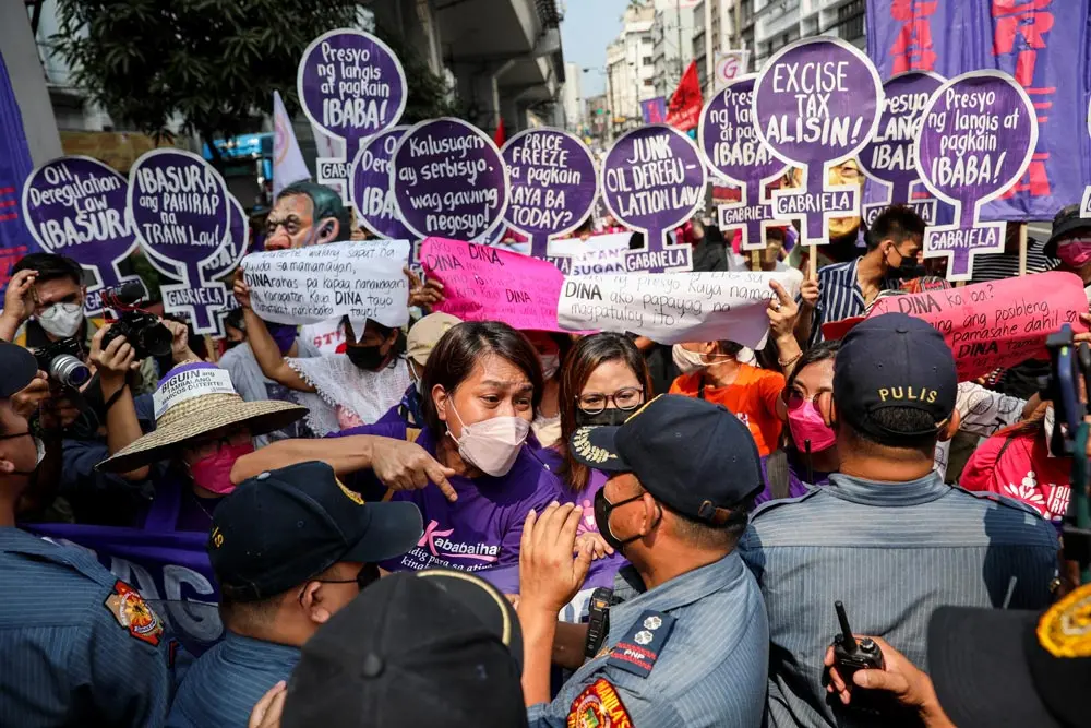 08 March 2022, Philippines, Manila: Policemen block activists as they march to mark International Women's Day in Manila, Philippines. Various groups protested against the series of oil price hikes in the country and called for the rights and struggles of women. Photo: Basilio Sepe/ZUMA Press Wire/dpa.