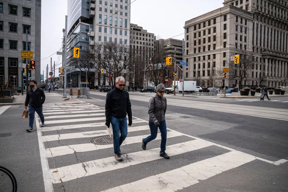 22 March 2022, Canada, Toronto: Pedestrians cross a street in Toronto. Mask mandate against COVID-19 has been lifted in Canadian Province Ontario after almost a year and a half. Photo: Katherine Cheng/SOPA Images via ZUMA Press Wire/dpa.
