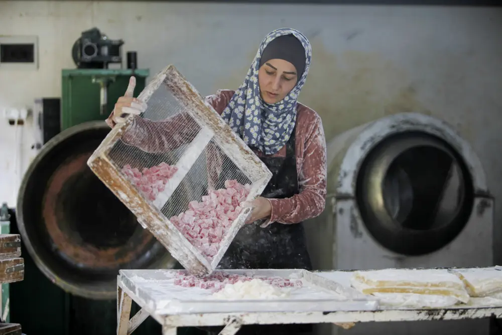 02 April 2022, Palestinian Territories, Nablus: A Palestinian woman prepares sweet halqum, an Iraqi-Turkish dessert, which is usually served during the Muslim holy month of Ramadan, at her shop in the West Bank city of Nablus. Photo: Nasser Ishtayeh/SOPA Images via ZUMA Press Wire/dpa-