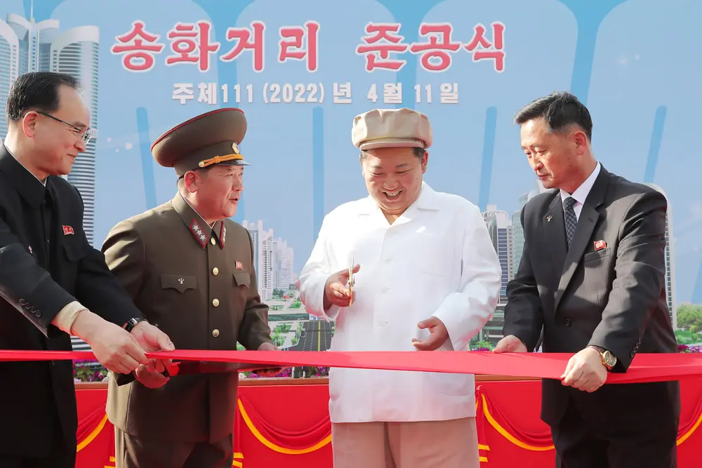 HANDOUT - 11 April 2022, North Korea, Pyongyang: A picture provided by the North Korean state news agency (KCNA) on 12 April 2022, shows North Korean leader Kim Jong-un (2nd from R) cutting the red tape during a dedication ceremony for the Songhwa District, built in eastern Pyongyang and containing 50000 new apartments, resolving the capital city's housing shortage. Photo: -/KCNA/dpa - ATTENTION: editorial use only and only if the credit mentioned above is referenced in full.