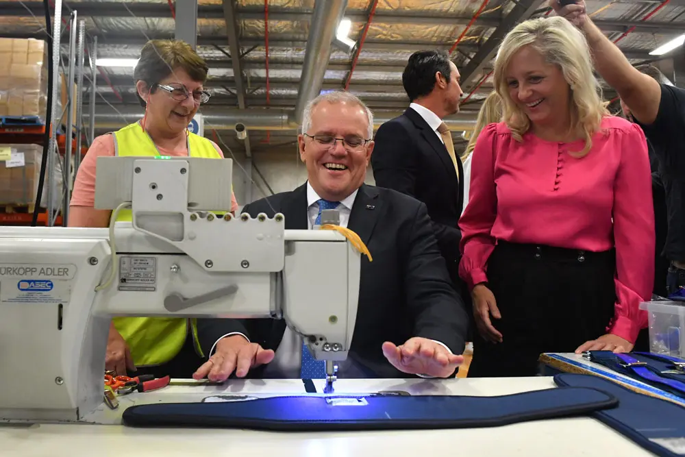 13 April 2022, Australia, Sydney: Australian Prime Minister Scott Morrison (C) sewing during a visit to SpanSet webbing based facility on Day 3 of the 2022 federal election campaign. Photo: Mick Tsikas/AAP/dpa.
