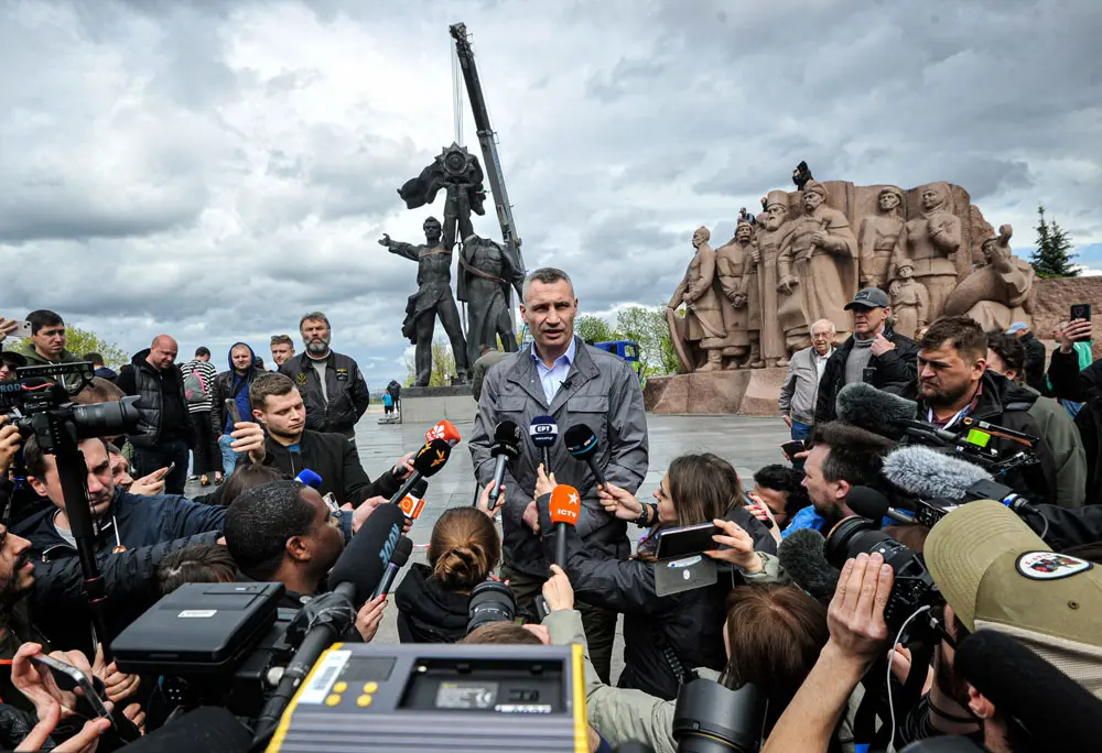 26 April 2022, Ukraine, Kiev: Vitali Klitschko (C), mayor of Kiev, talks to journalists near the Soviet-era monument during the demolition process, amid Russian invasion of Ukraine. The bronze sculpture of two workers was installed in the centre of Kiev in 1982 "to celebrate the reunification of Ukraine and Soviet Union". Photo: Sergei Chuzavkov/SOPA Images via ZUMA Press Wire/dpa.