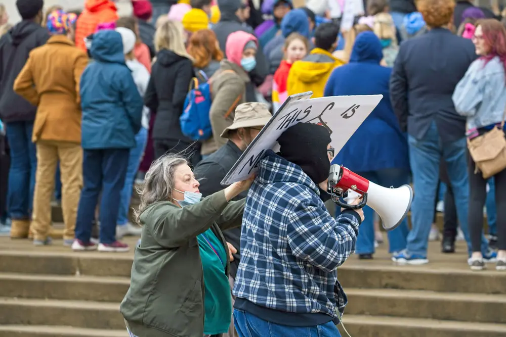 03 May 2022, US, Bloomington: A pro-abortion protester hits with a placard a counter-protester speaking on a megaphone during a rally in front of the McLean County Museum of History in downtown Bloomington to protest the possibility of overturning the Roe v. Wade, a landmark decision of the US Supreme Court in which the Court ruled that the Constitution of the United States protects a pregnant woman's liberty to choose to have an abortion without excessive government restriction. Photo: Alan Look/ZUMA Press Wire/dpa.