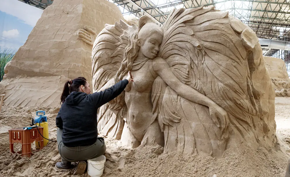 06 May 2022, Schleswig-Holstein, Luebeck-Travemuende: Ukrainian artist Iryna Kalyuzhna works on her sand sculpture "Brazil" during the sand sculpture exhibition "Journey around the world" which opens on 07 May and lasts until the end of October. Photo: Markus Scholz/dpa.