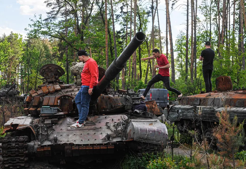 29 May 2022, Ukraine, Dmytrivka: People walk on destroyed Russian military armoured vehicles at Dmytrivka village near the Ukrainian capital Kiev. Photo: Sergei Chuzavkov/SOPA Images via ZUMA Press Wire/dpa.