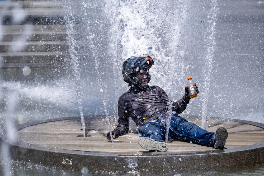31 May 2022, US, New York: A man sits in the fountain in Washington Square Park to beat the heat. Photo: Milo Hess/ZUMA Press Wire/dpa.