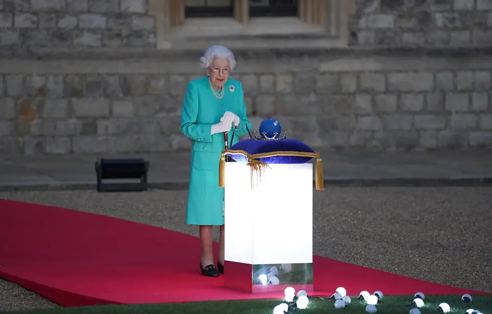 02 June 2022, United Kingdom, London: Queen Elizabeth II symbolically lights the main Jubilee bonfire at Windsor Castle on the first day of the Queen's Platinum Jubilee celebrations, part of a chain of more than 3,500 flaming tributes to her 70-year reign. Photo: Steve Parsons/PA Wire/dpa.