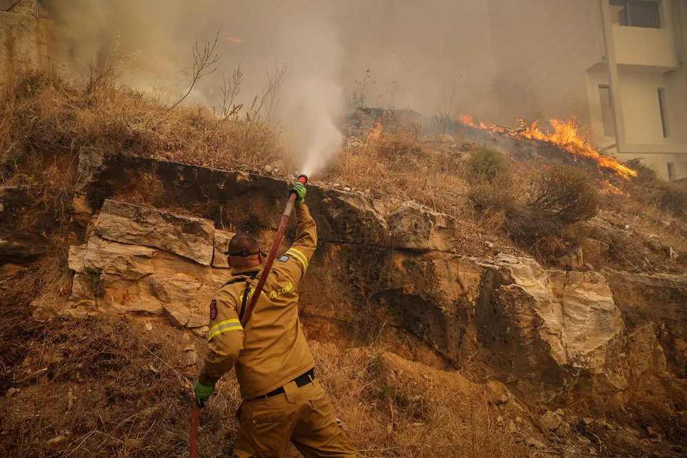 04 June 2022, Greece, Athens: A firefighter tries to extinguish flames during a wildfire in the suburb of Voula. Greek authorities ordered a limited evacuation in the coastal suburb of Voula, southern Athens, as strong winds fanning a raging fire have changed its direction, threatening residential area. Photo: Eurokinissi/Eurokinissi via ZUMA Press Wire/dpa.