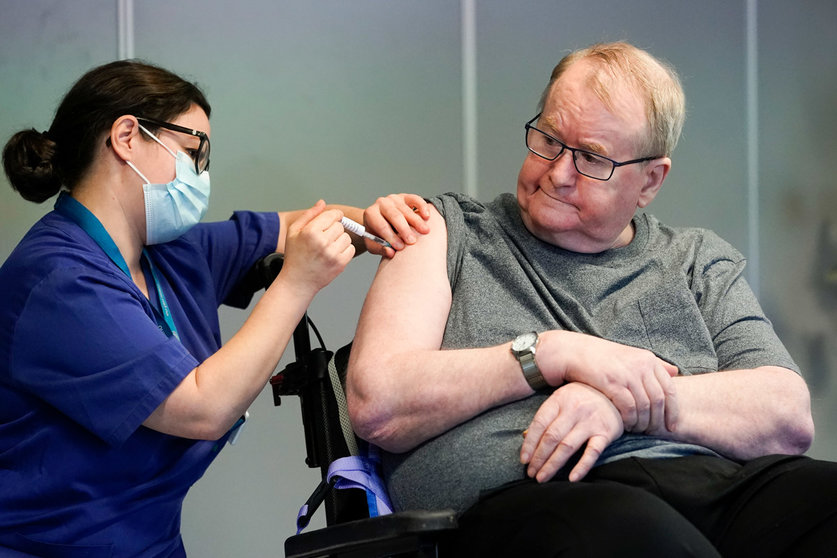 27 December 2020, Norway, Oslo: Nurse Maria Golding (l) vaccinates 67-year-old Svein Andersen with the Coronavirus vaccine from Biontech/Pfizer. Photo: Fredrik Hagen/NTB/dpa