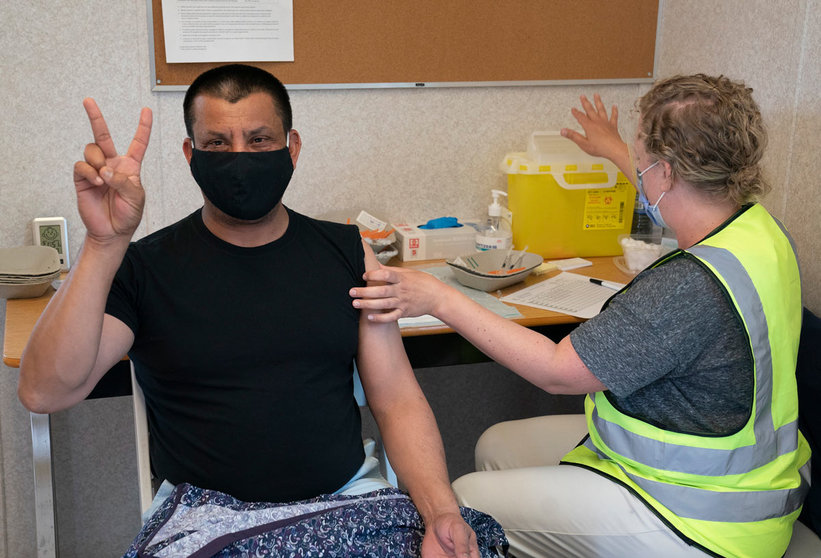 16 June 2021, Canada, Delta: A man gives the victory sign as he receives a dose of a COVID-19 vaccine at a truck stop. Photo: Jonathan Hayward/The Canadian Press via ZUMA/dpa