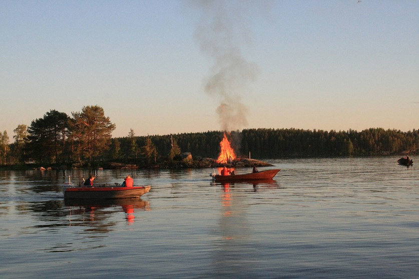 People watching a typical Midsummer bonfire in a lake. Photo: Walter Bieck/Pixabay/File photo.
