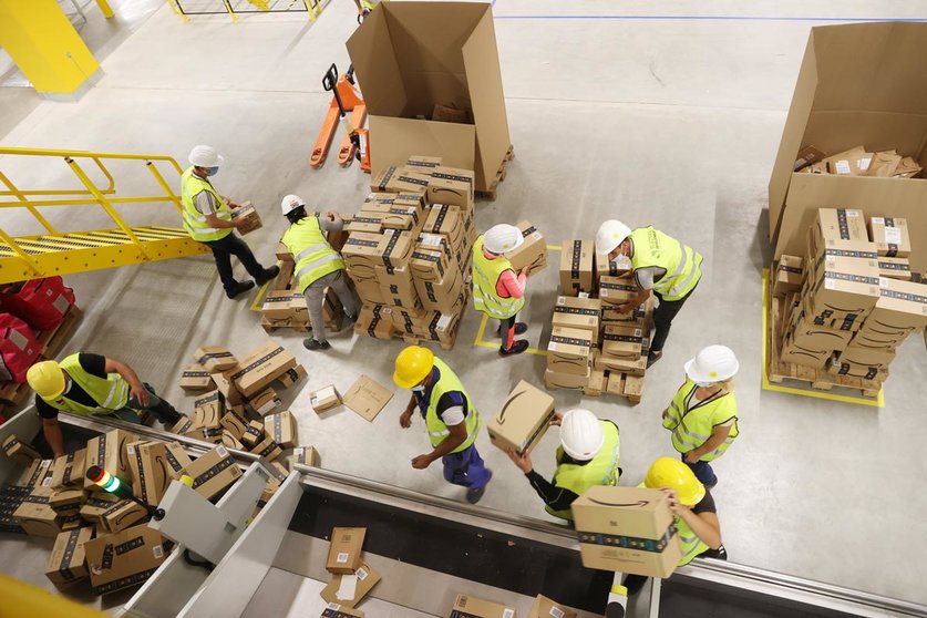 21 July 2021, Thuringia, Gera: Employees transport shipping boxes during a trial run at the logistics hall of the new Amazon logistics centre in Gera, a new site by the e-commerce company that will create around 1000 jobs. Photo: Bodo Schackow/dpa-zentralbild/dpa