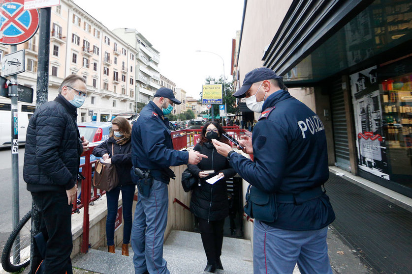 06 December 2021, Italy, Rome: Police officers check passengers' Coronavirus health passes, known as the Green Pass, in front of the entrance of a subway station in Rome. Photo: Cecilia Fabiano/LaPresse via ZUMA Press/dpa.
