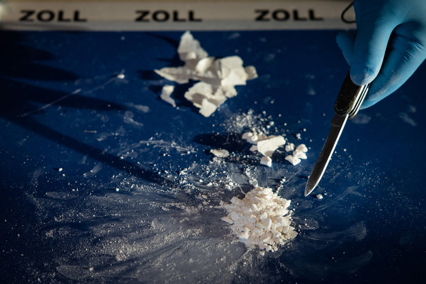 16 December 2021, Hamburg: A customs officer diplays pressed and highly concentrated cocaine from after a large cocaine stash was seized, during a press conference of the Hamburg customs. Photo: Christian Charisius/dpa.