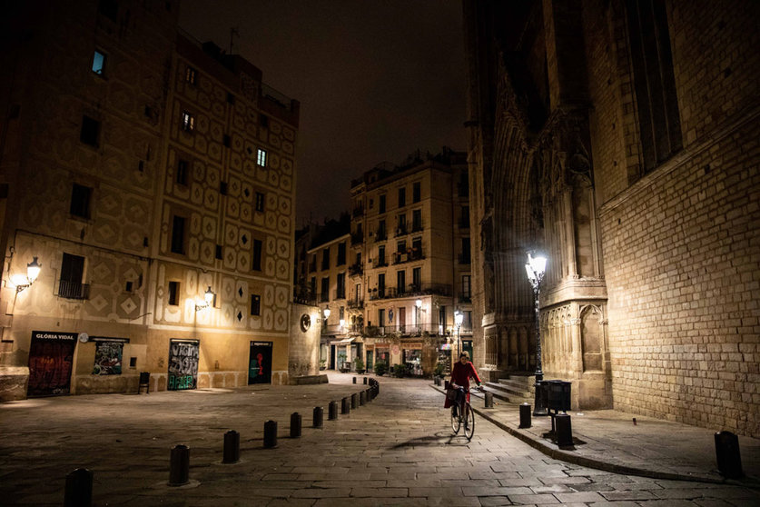 24 December 2021, Spain, Barcelona: A woman rides her bike in central Barcelona street during curfew time that was imposed as part of coronavirus measures. Photo: Kike Rincón/EUROPA PRESS/dpa.