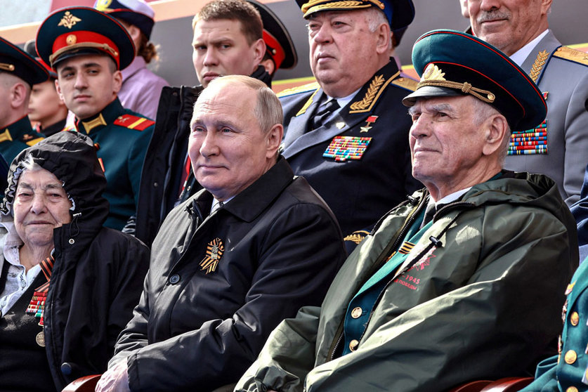 HANDOUT - 09 May 2022, Russia, Moscow: Russian President Vladimir Putin (C) watches the Victory Day military parade marking the 77th anniversary of the victory over Nazi Germany during World War II at Red Square in central Moscow. Photo: -/Kremlin/dpa - ATTENTION: editorial use only and only if the credit mentioned above is referenced in full.