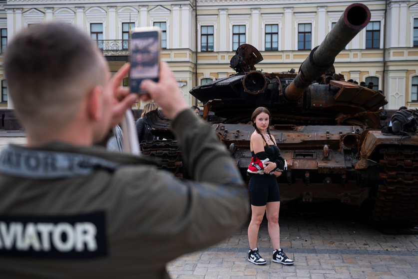 FILED - 27 May 2022, Ukraine, Kiev: A girl poses next to a destroyed Russian tank on display in Mikhailovsky Square. Photo: Deml Ondøej/CTK/dpa.