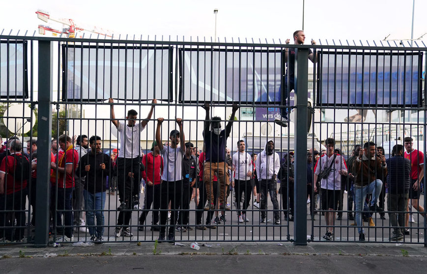 28 May 2022, France, Paris: People try to climb gates outside the ground as the kick off is delayed during the UEFA Champions League final soccer match between Liverpool FC and Real Madrid CF at the Stade de France. Photo: Adam Davy/PA Wire/dpa.
