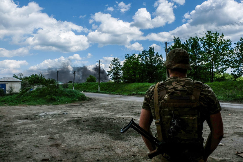 27 May 2022, Ukraine, Lysychans'k: A soldier looks at the smoke coming from the oil refinery of Lysychans'k. Lysychans'k is an elongated city on the high right bank of the Donets River in the Luhansk region. The town is now the frontline since the Russian destroyed the bridge connecting Severodonetsk to Lysychans'k, Russian troops are attacking the city and moving towards it. Photo: Rick Mave/SOPA Images via ZUMA Press Wire/dpa.