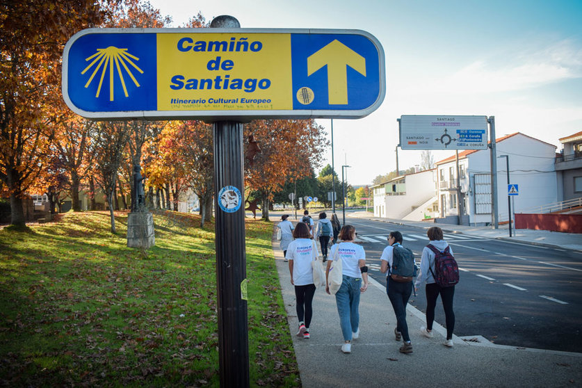 A group of young visitors to Santiago de Compostela passing by a sign indicating the Saint James Way. Photo: Pablo Morilla.