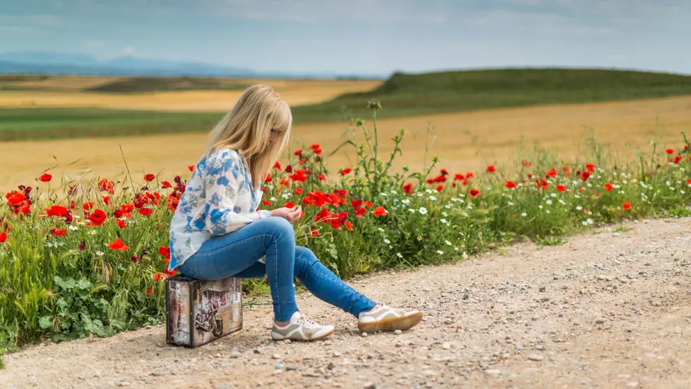 Blonde-woman-jeans-flowers-suitcase