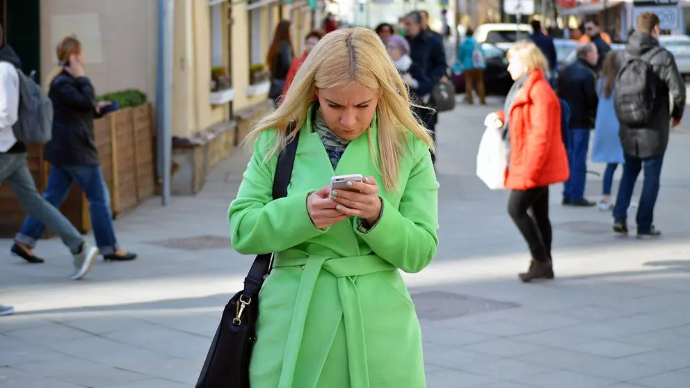 Woman-girl-mobile-blonde-street-people-passing by Pixabay