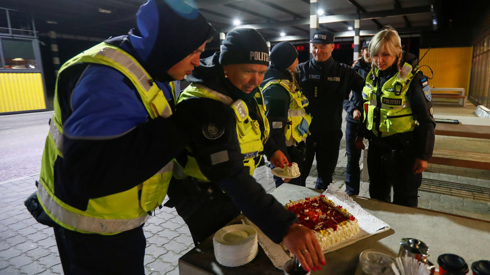 Estonian police and border guard officers pick pieces of cake at border crossing point between Estonia and Latvia, as travel restrictions for residents of Latvia, Lithuania and Estonia are lifted during the coronavirus disease (COVID-19) outbreak in Ikla, Estonia May 15, 2020. REUTERS/Ints Kalnins