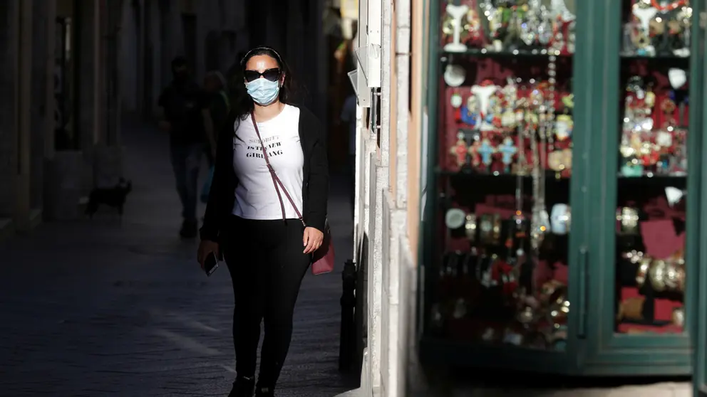 FILE PHOTO: A woman wearing a face mask walks in a street, as Italy begins to ease some of the restrictions of the coronavirus disease (COVID-19) lockdown, in Taormina, Italy, May 12, 2020. REUTERS/Antonio Parrinello