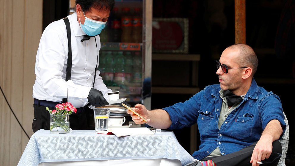 A man gets served at a restaurant, as Italy eases some of the lockdown measures put in place during the coronavirus disease (COVID-19) outbreak, in Rome, Italy May 18, 2020. REUTERS/Guglielmo Mangiapane