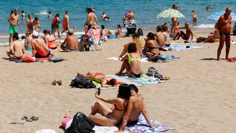 A couple takes a selfie while sunbathing on Las Canteras beach (Gran Canaria). Photo: Borja Suarez/Reuters/File photo.