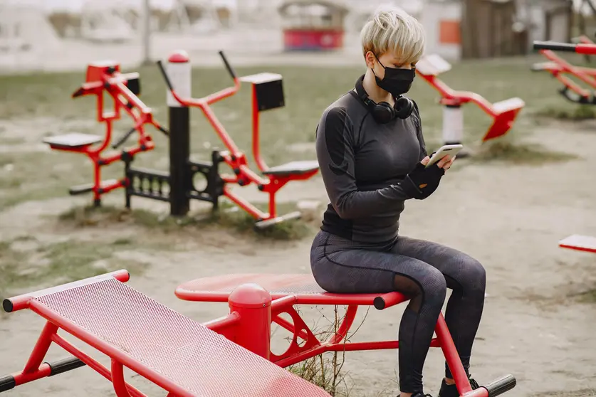 Woman-face-mask-gymnastics-coronavirus-smartphone