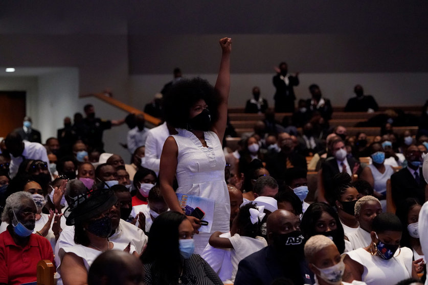 A woman raises her fist during the funeral service for African-American citizen George Floyd, who was killed on 25 May 2020 by a white policeman in the US city of Minneapolis, at the Fountain of Praise Church. Photo: David J. Phillip/POOL via Zuma/dpa