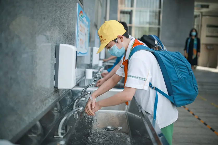 School students wash their hands at a school yard as thousands of students started returning to their classes after a long closure amid the coronavirus pandemic. Photo: -/TPG via ZUMA Press/dpa