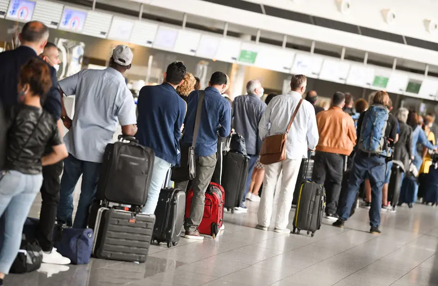 15 June 2020, Hessen, Frankfurt_Main: Passengers queue at Terminal 1 of Frankfurt Airport in front of a check-in counter after The travel ban for 27 European countries was lifted, which waas imposed due to the coronavirus pandemic. Photo: Arne Dedert/dpa