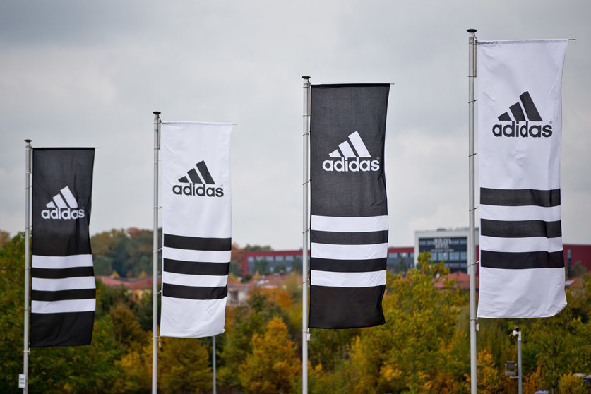 Flags with the logos of the sporting goods manufacturer Adidas wave. Adidas&#39; executive board member for global human resources, Karen Parkin, has stepped down after being accused of racism. Photo: Daniel Karmann/dpa