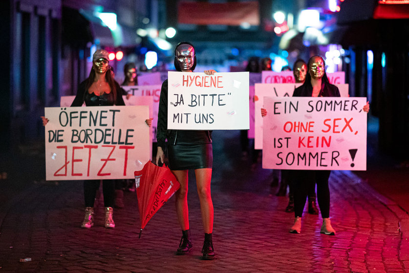 28 July 2020, Hamburg: Sex workers hold signs and placards during a demonstration in Herbertstrasse against the lockdown of the brothels due to the spread of the coronavirus (COVID-19) pandemic. Photo: Daniel Reinhardt/dpa