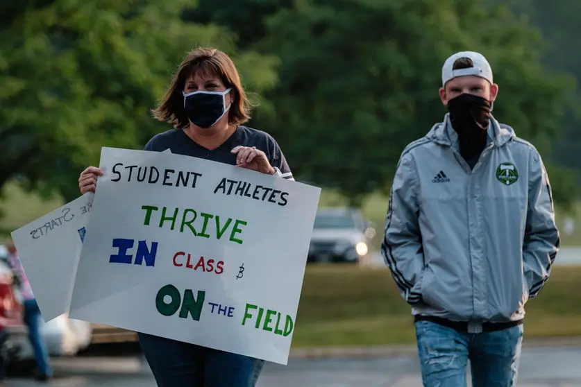 04 August 2020, US, Copley: A woman holds a placard during the Students, parents, and staff of Copley-Fairlawn City Schools protest outside the school board office shortly before a vote set to decide the future of learning due to concerns over Coronavirus (Covid-19). Photo: Andrew Dolph/dpa.