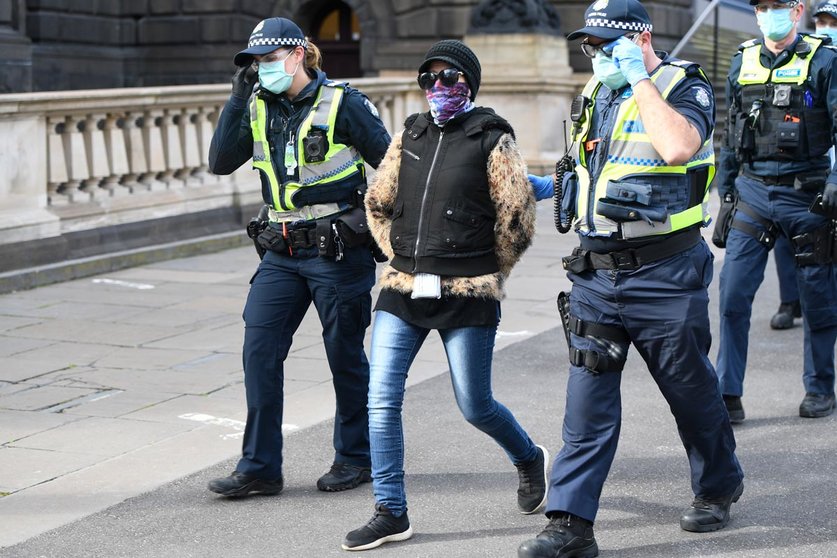 09 August 2020, Australia, Melbourne: Policemen detain a woman during an anti-lockdown protest after the police warned people planning to attend a Melbourne protest that it’s a breach of COVID-19 restrictions. Photo: Erik Anderson/dpa.