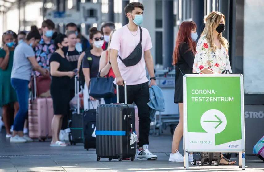 16 August 2020, Baden-Wuerttemberg, Stuttgart: Passengers wait in a long queue in front of a coronavirus test centre at Stuttgart Airport. Photo: Christoph Schmidt/dpa