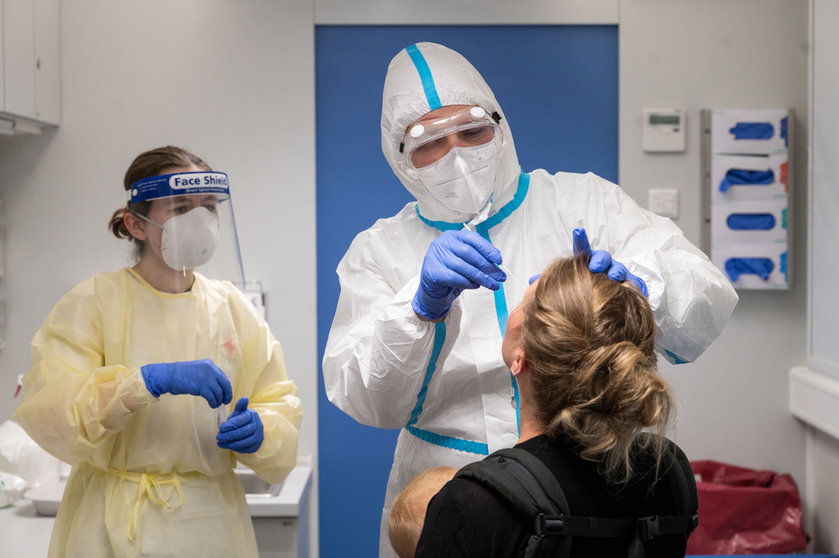 13 August 2020, Baden-Wuerttemberg, Stuttgart: A traveler (R) who has been in Switzerland gets tested by medic at a coronavirus testing center set to allow travellers returning from risk areas to take COVID-19 tests at the main railway station in Stuttgart. Photo: Marijan Murat/dpa.