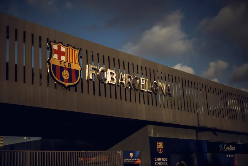 27 August 2020, Spain, Barcelona: A general view of the Barcelona emblem behind the gates of the Camp Nou stadium near where fans gathered to protest against club president Josep Maria Bartomeu after Argentina&#39;s Lionel Messi asked the club to leave after almost 20 years among its ranks. Photo: Matthias Oesterle/dpa.