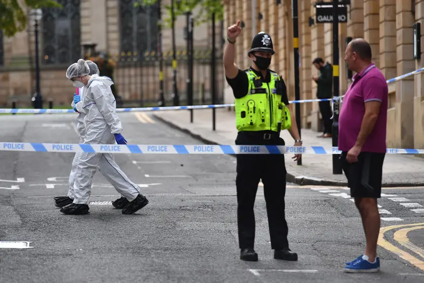 06 September 2020, England, Birmingham: Forensic officers walk past a policeman directing a member of the public, inside the cordoned area on Barwick Street in Birmingham after a number of people were stabbed in the city centre. West Midlands Police said they were called to reports of a stabbing at around 12.30am on Sunday and a number of other stabbings were reported in the area at around the same time. Photo: Jacob King/dpa.