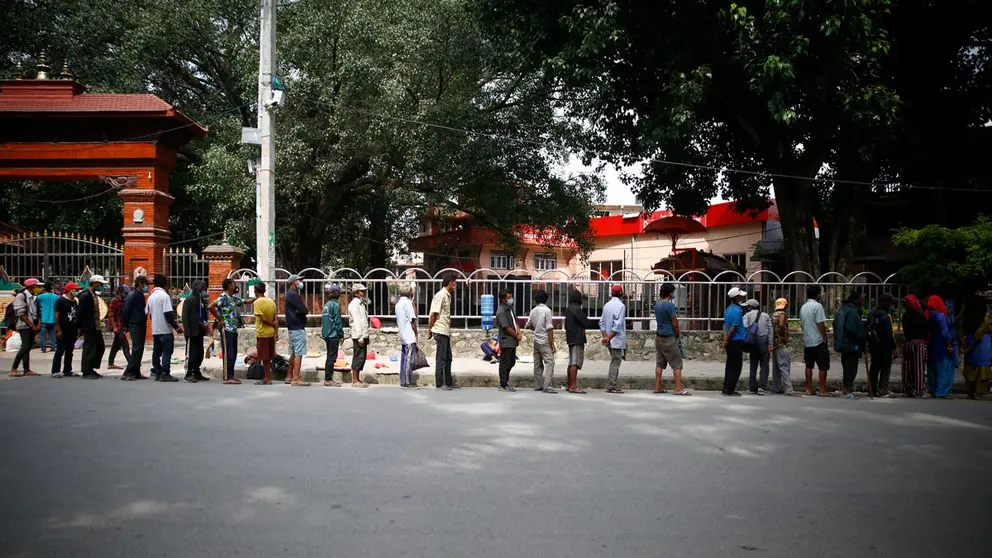 04 September 2020, Nepal, Lalitpur: Daily wagers and homeless people queue for free hot meals distributes by Hiteri foundation during the coronavirus pandemic lockdown. Photo: Skanda Gautam/dpa.