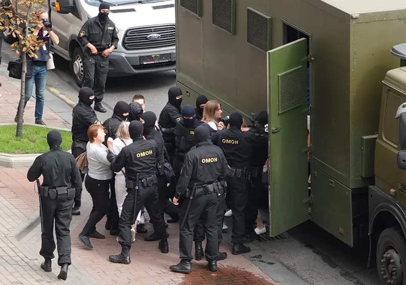 30 August 2020, Belarus, Minsk: Riot police arrest demonstrators into a prisoner transport vehicle, as thousands of people take part in mass demonstration against President Alexander Lukashenko. Photo: Ulf Mauder/dpa.