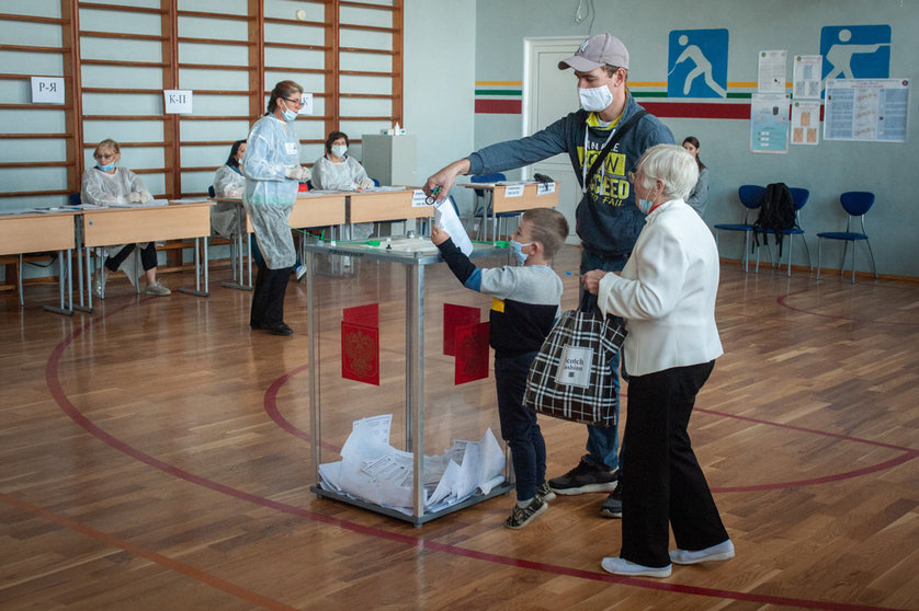 12 September 2020, Russia, Tambow: A small child wearing a face mask casts his father&#39;s vote in a ballot box at a polling station during the 2020 Regional elections. Photo: Lev Vlasov/dpa.