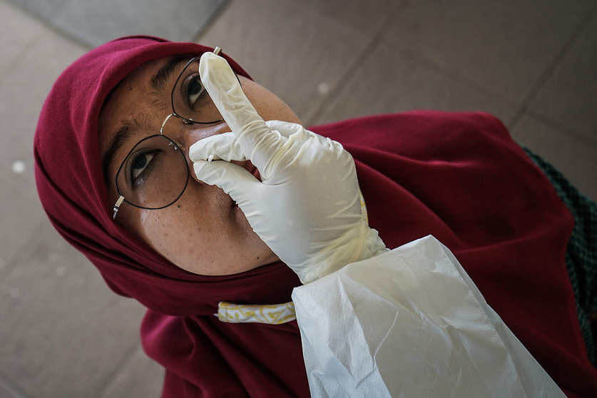 10 September 2020, Indonesia, Makassar: A health worker wearing full protective gear takes a swab from a woman for coronavirus test. Photo: Herwin Bahar/dpa.