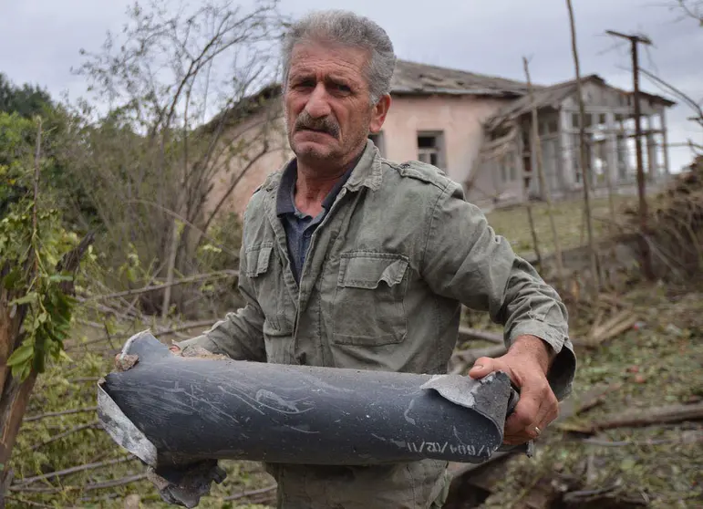 HANDOUT - 28 September 2020, Azerbaijan, Martuni: A man holds remains of a rocket shell, fired at the Martuni town in the self-proclaimed Republic of Nagorno-Karabakh, also known as Artsakh. Heavy fighting has broken out in the disputed Nagorno-Karabakh region in the southern Caucasus between neighbouring Azerbaijan and Armenia on Sunday. Photo: -/Armenian Foreign Ministry/dpa.