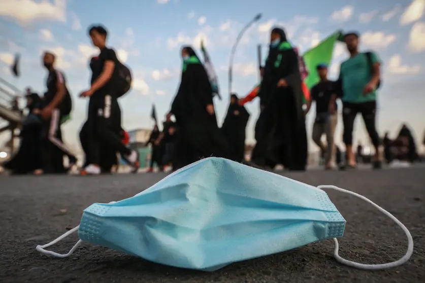 05 October 2020, Iraq, Karbala: A used face mask can be seen on the street during the Shia Muslims march from Baghdad to visit the Husayn Mosque in Karbala on the occasion of Arba&#39;een, also known as Chehelom, a religious observance that occurs forty days after the Day of Ashura to commemorate the martyrdom of Husayn ibn Ali, the grandson of the Islamic Prophet Muhammad, who was killed on the 10th day of the month of Muharram, according to Islamic calendar. Photo: Ameer Al Mohammedaw/dpa.