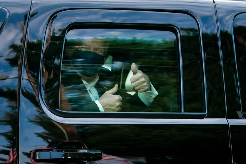 HANDOUT - 04 October 2020, US, Bethesda: US President Donald Trump greets supporters during a drive by outside of Walter Reed National Military Medical Center, where he is being treated from coronavirus. Photo: Tia Dufour/White House /dpa.